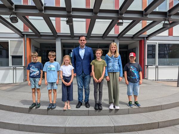 B�rgermeister Torben Blome (Mitte) mit dem Kinderrat L�gde: stehend (v. links) Jakob, Elias, Nele und stehend (v. rechts) Mattis, Finja, Jolin im Rahmen des L�gder Ferienspa� 2024